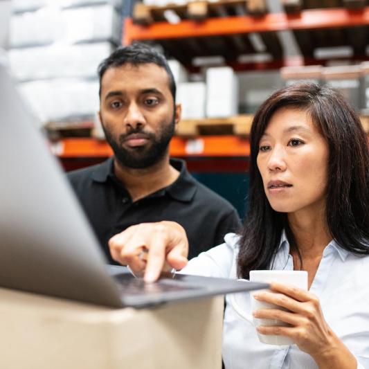 A man and woman are looking at a computer screen