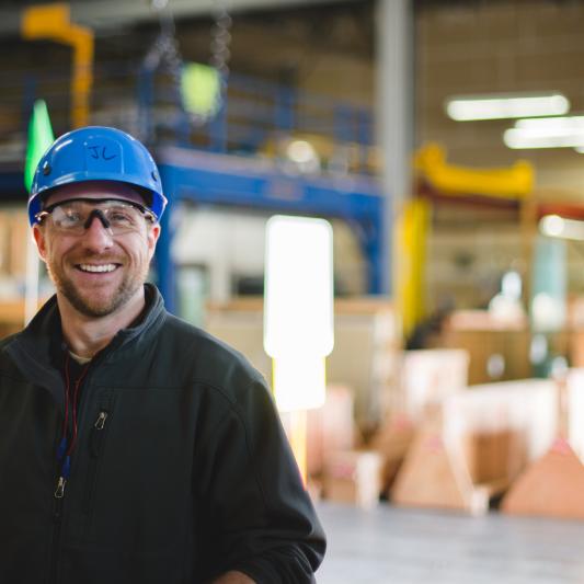 Man in blue hard hat standing on manufacturing floor