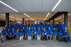 A large group of people wearing matching tshirts are posed for a photo