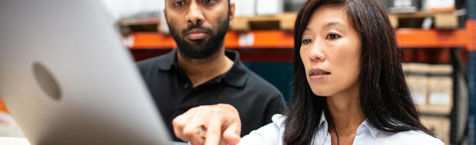 A man and woman are looking at a computer screen